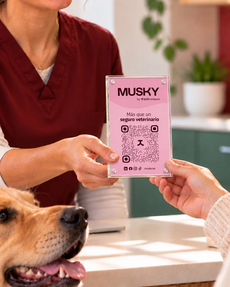 Una veterinaria entrega un código QR de Musky y un perro las observa